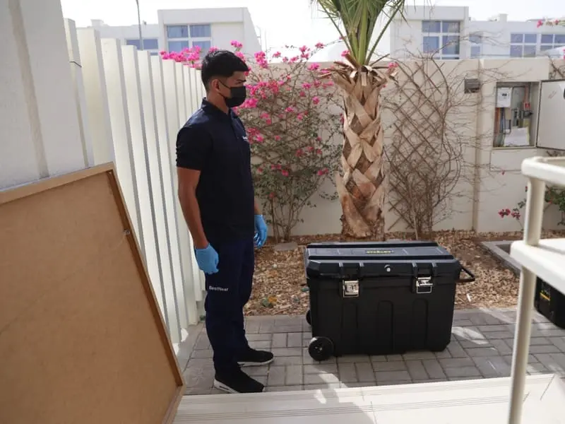 A BestNear technician arriving at a Dubai villa with an equipment case
